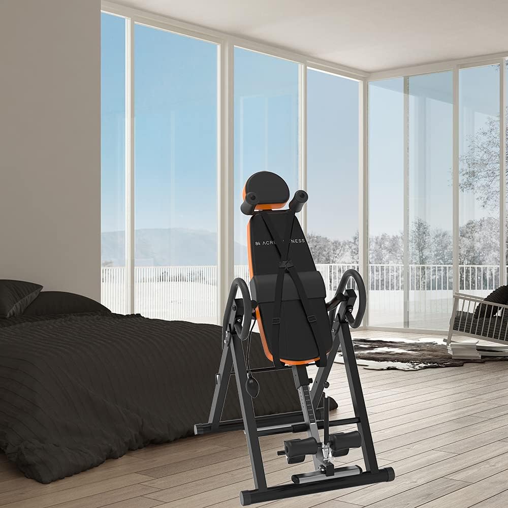 Craques heavy duty inversion table in black and orange set up in a modern bedroom with large windows