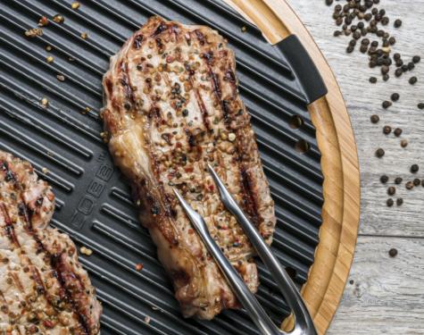 Cobb Premier Pro Griddle replacement with grilled steak and peppercorns on a wooden surface