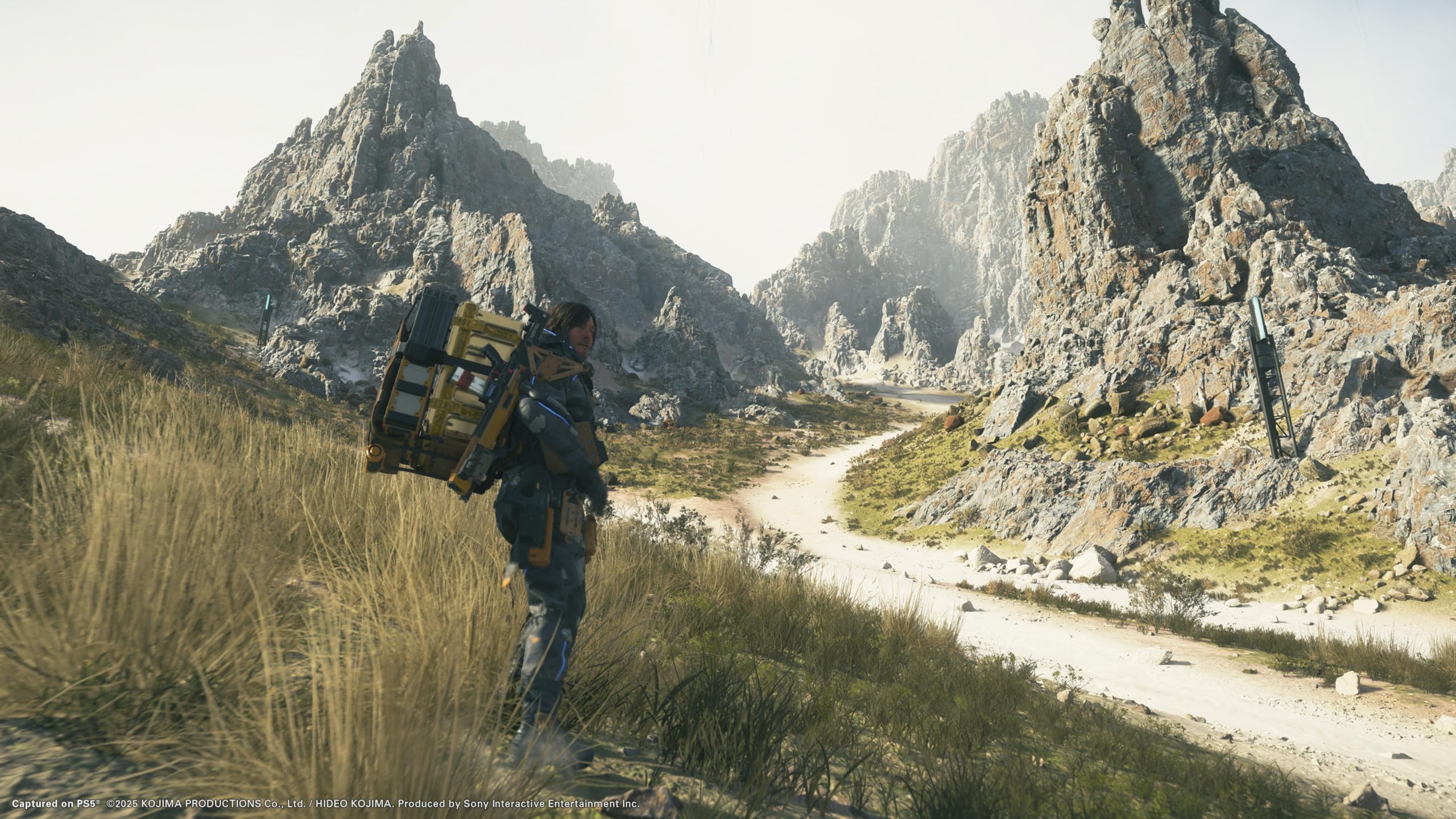 Death Stranding 2 Collector's Edition PS5 character carrying cargo walking along mountain path