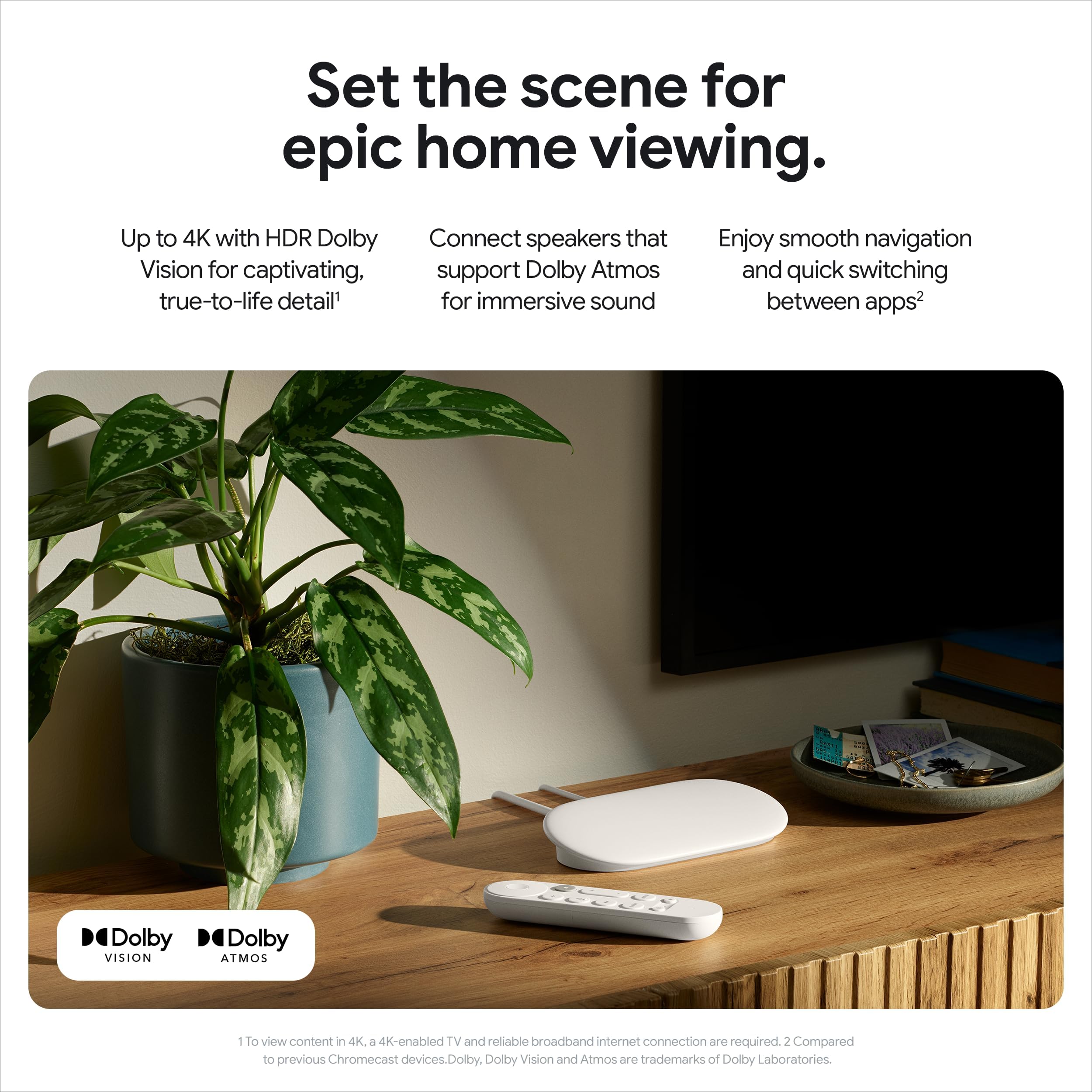 Craques 4K Google TV streaming device with remote on wooden table beside plant and mounted TV