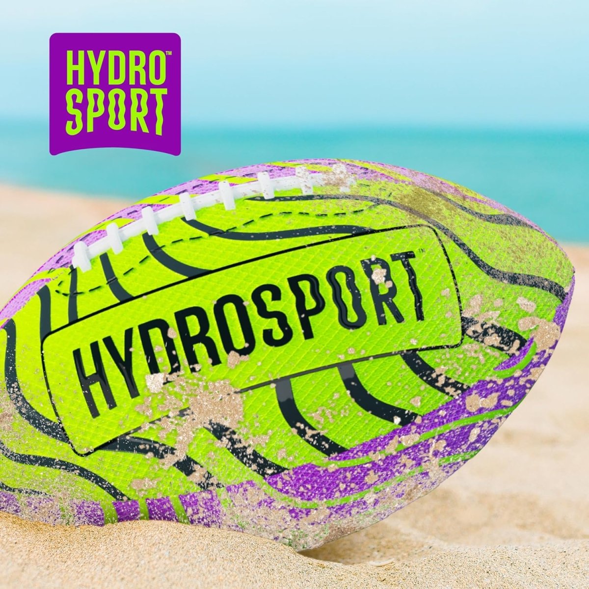 Hydrosport branded green and purple water football ball on sandy beach near ocean