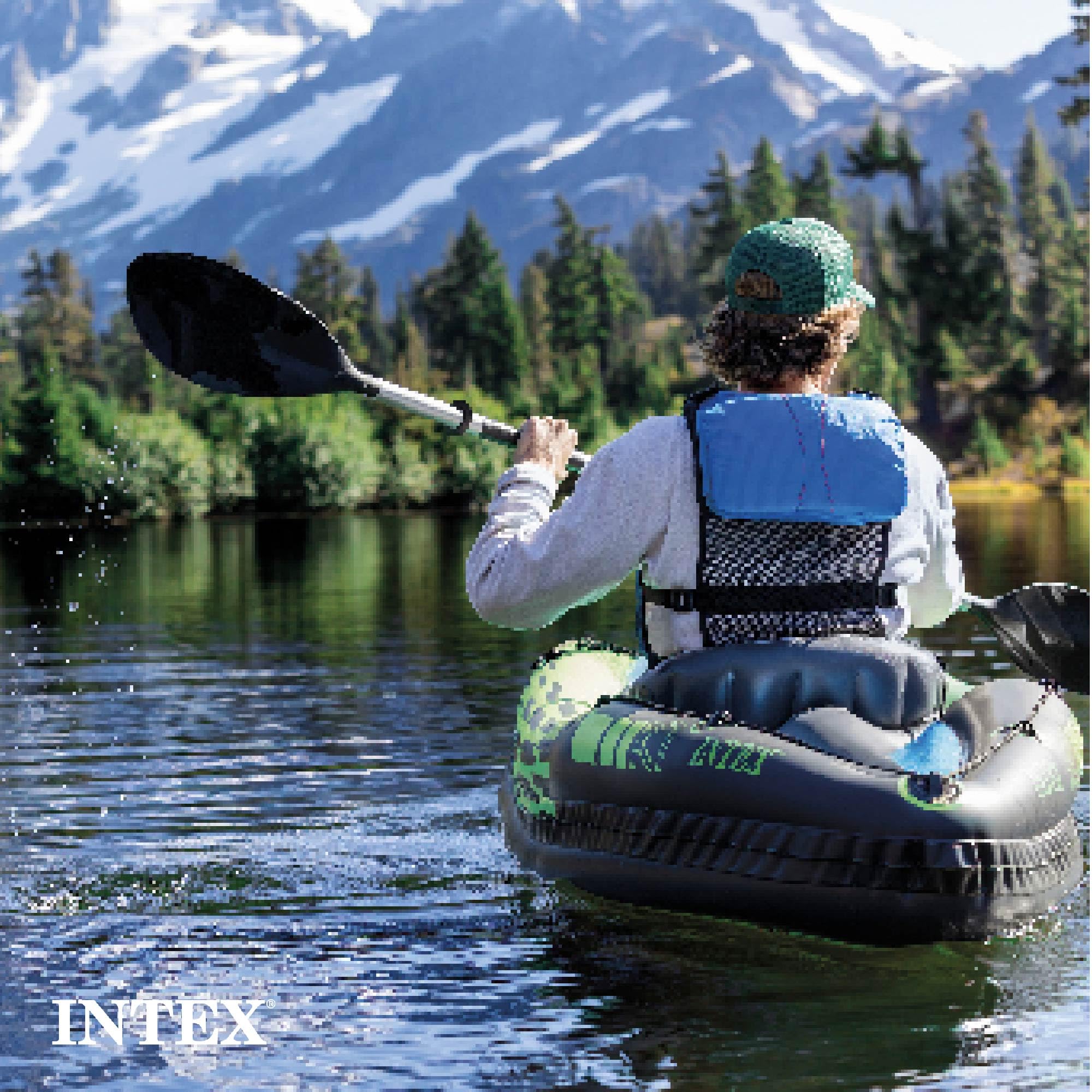 Person paddling an Intex Challenger inflatable kayak on a lake with mountains and trees in the background