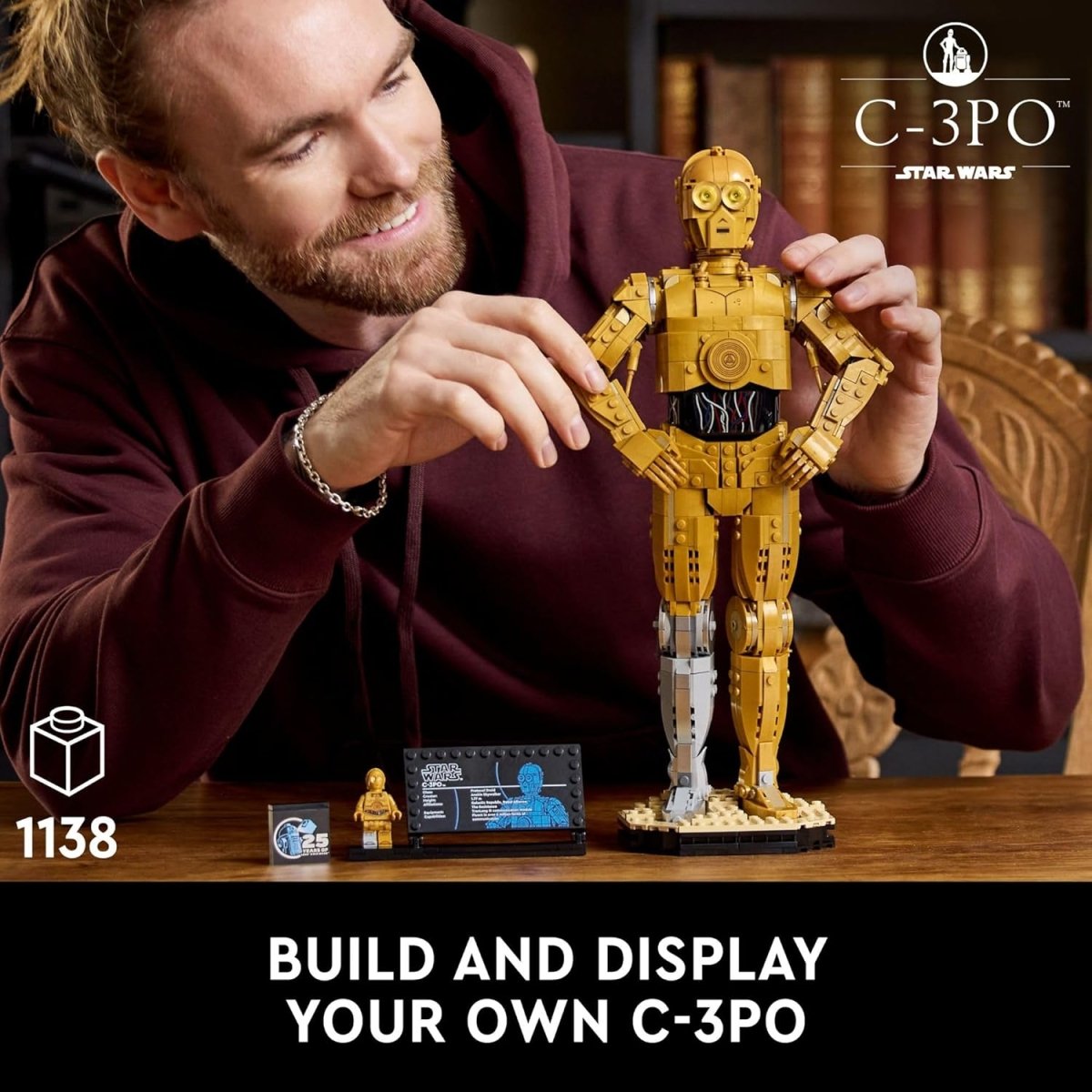 Man assembling LEGO Star Wars C-3PO droid figure with detailed gold design on wooden table