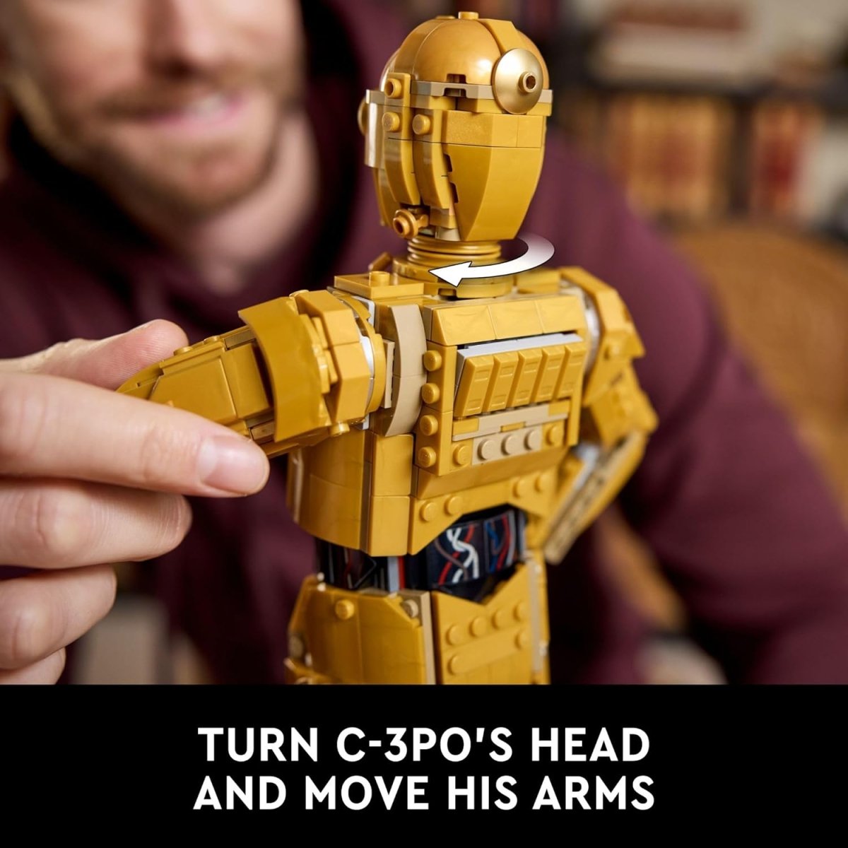 Hands adjusting LEGO Star Wars C-3PO droid figure's movable head and arms with blurred person in background