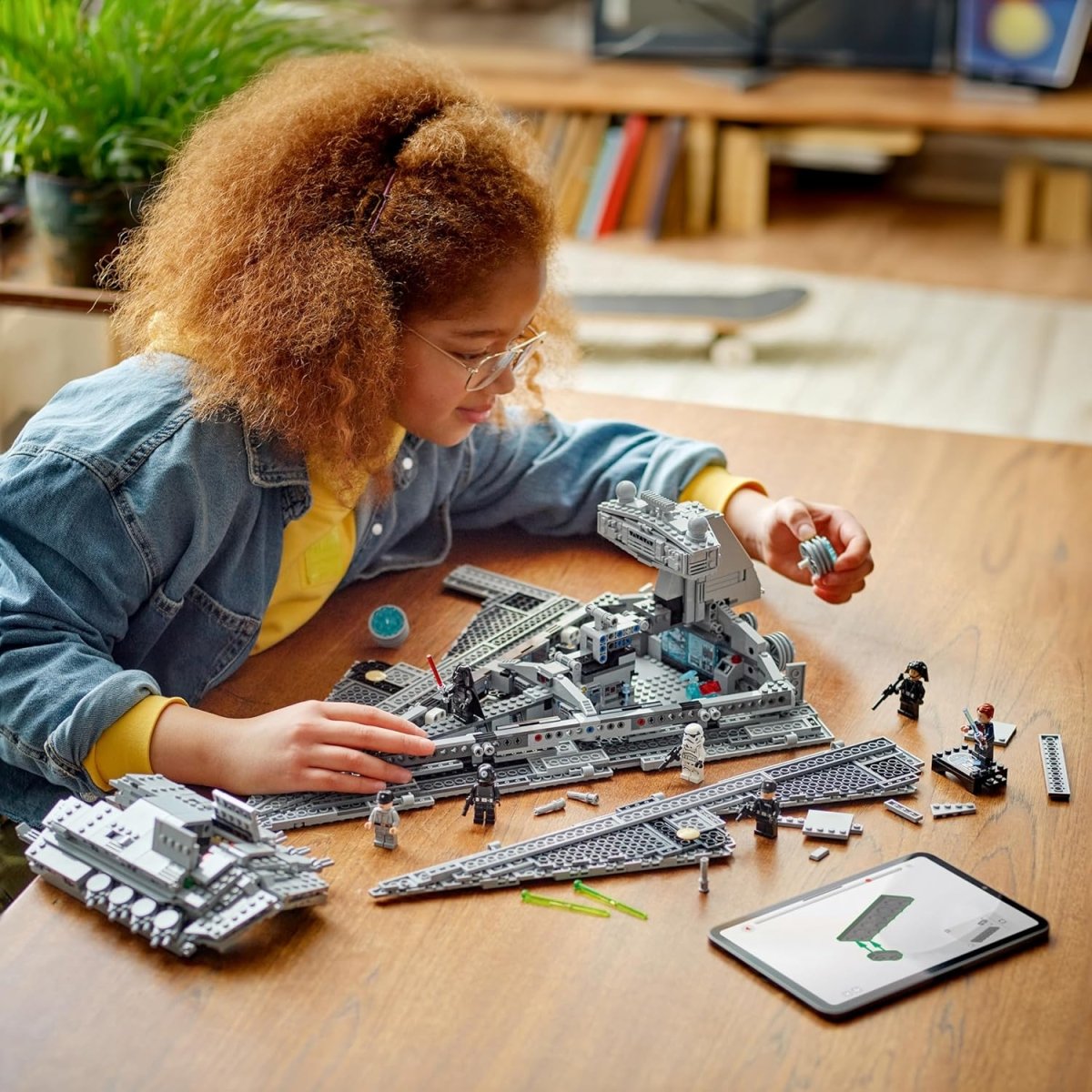 Child assembling the LEGO Star Wars Imperial Star Destroyer set with detailed pieces on a wooden table
