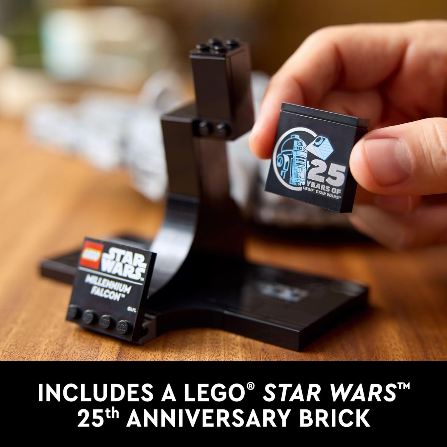 Hand holding 25th anniversary LEGO Star Wars Millennium Falcon set commemorative brick on display stand