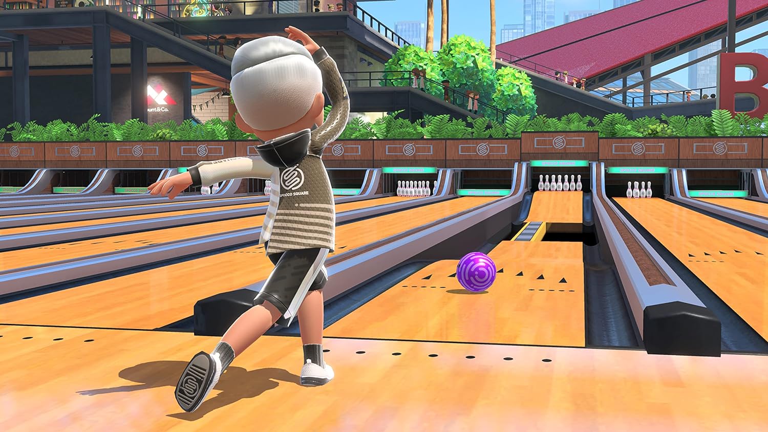 Character bowling a strike in vibrant bowling alley from Nintendo Switch Sports game