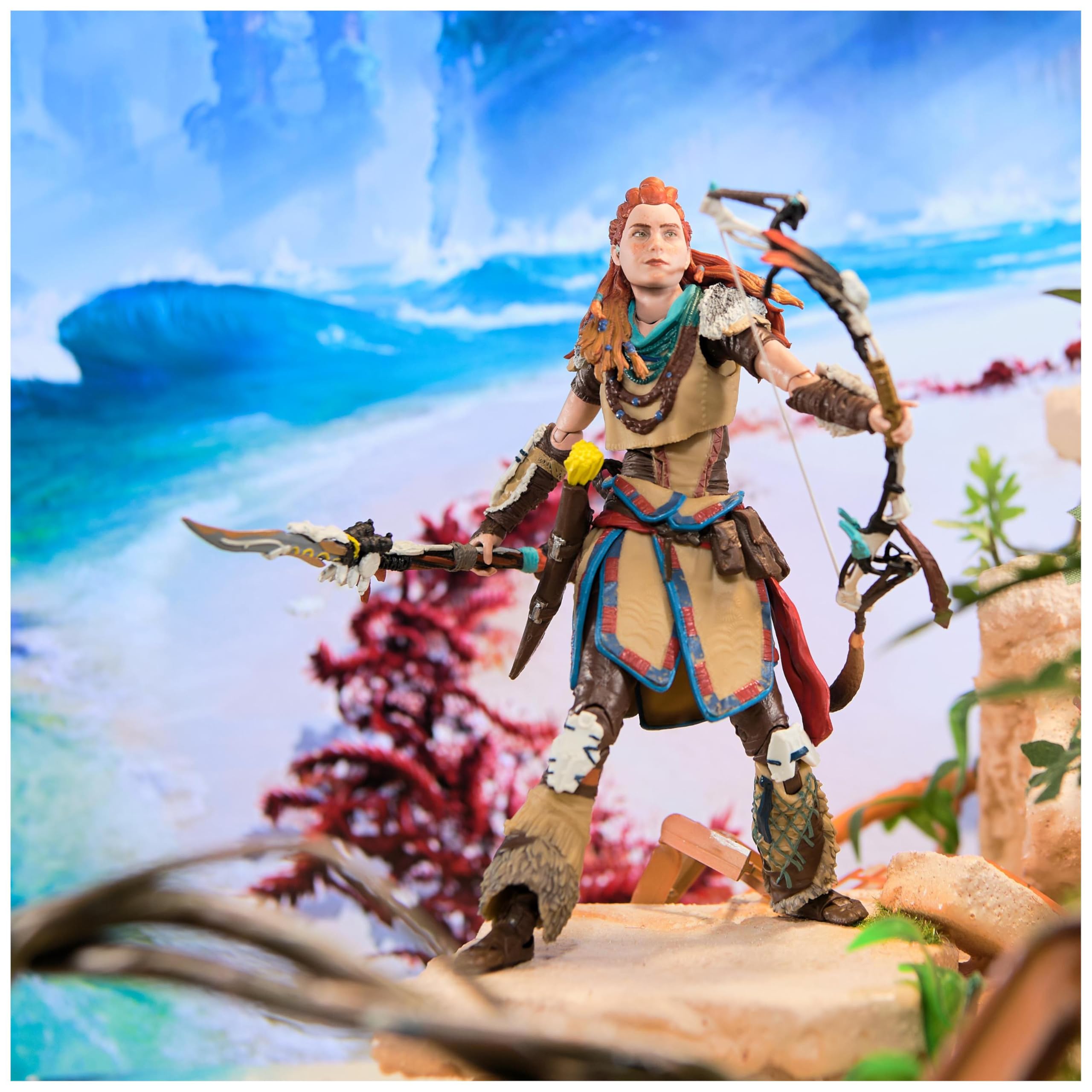 Kratos God of War Ragnarök action figure posed with bow and spear in detailed fantasy landscape background