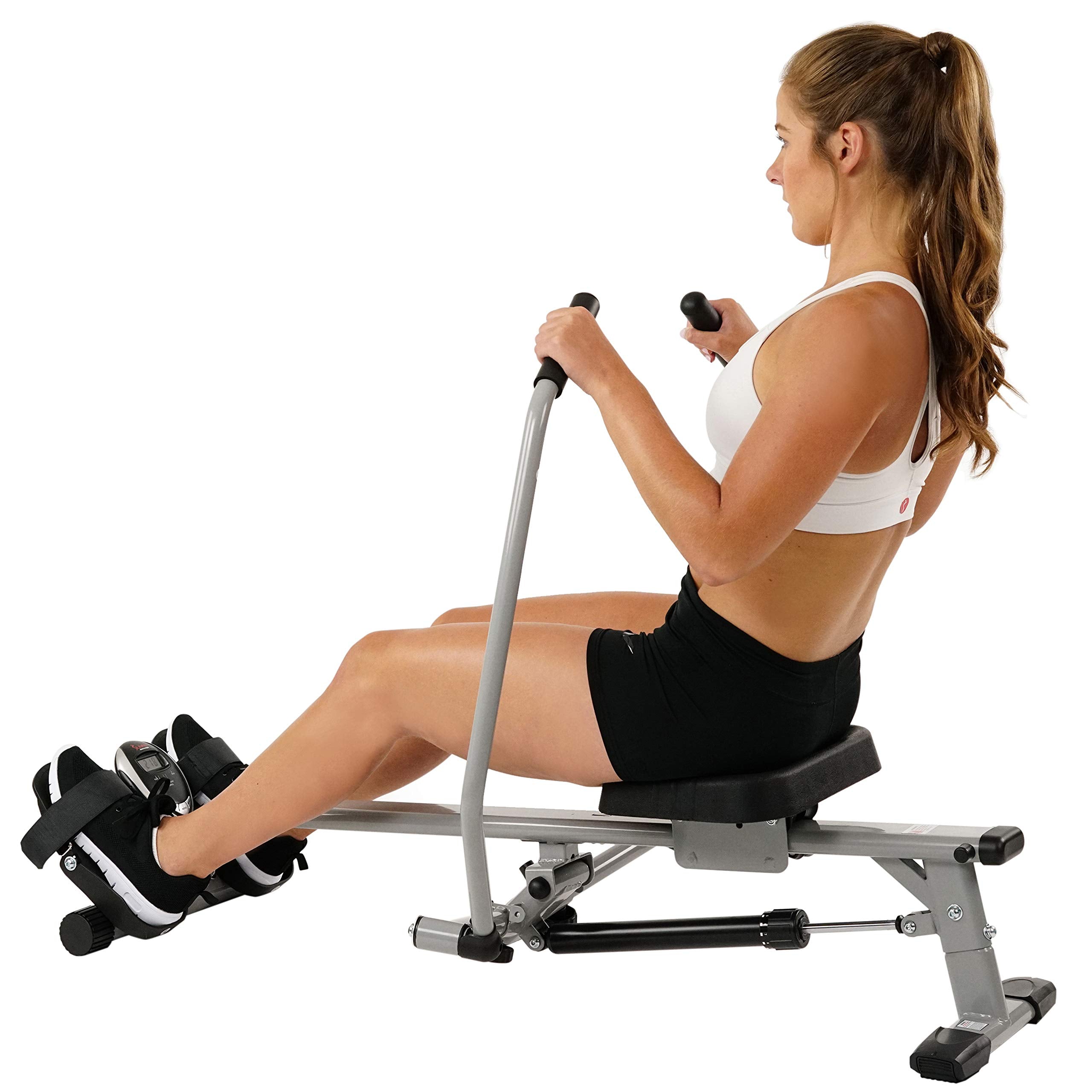 Woman using a craques compact rowing machine for home gym in black shorts and white sports bra