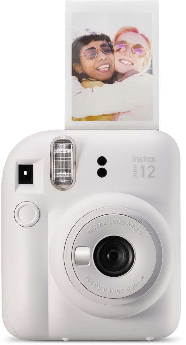 White Fujifilm Instax Mini 12 instant camera printing a photo of two friends smiling and hugging