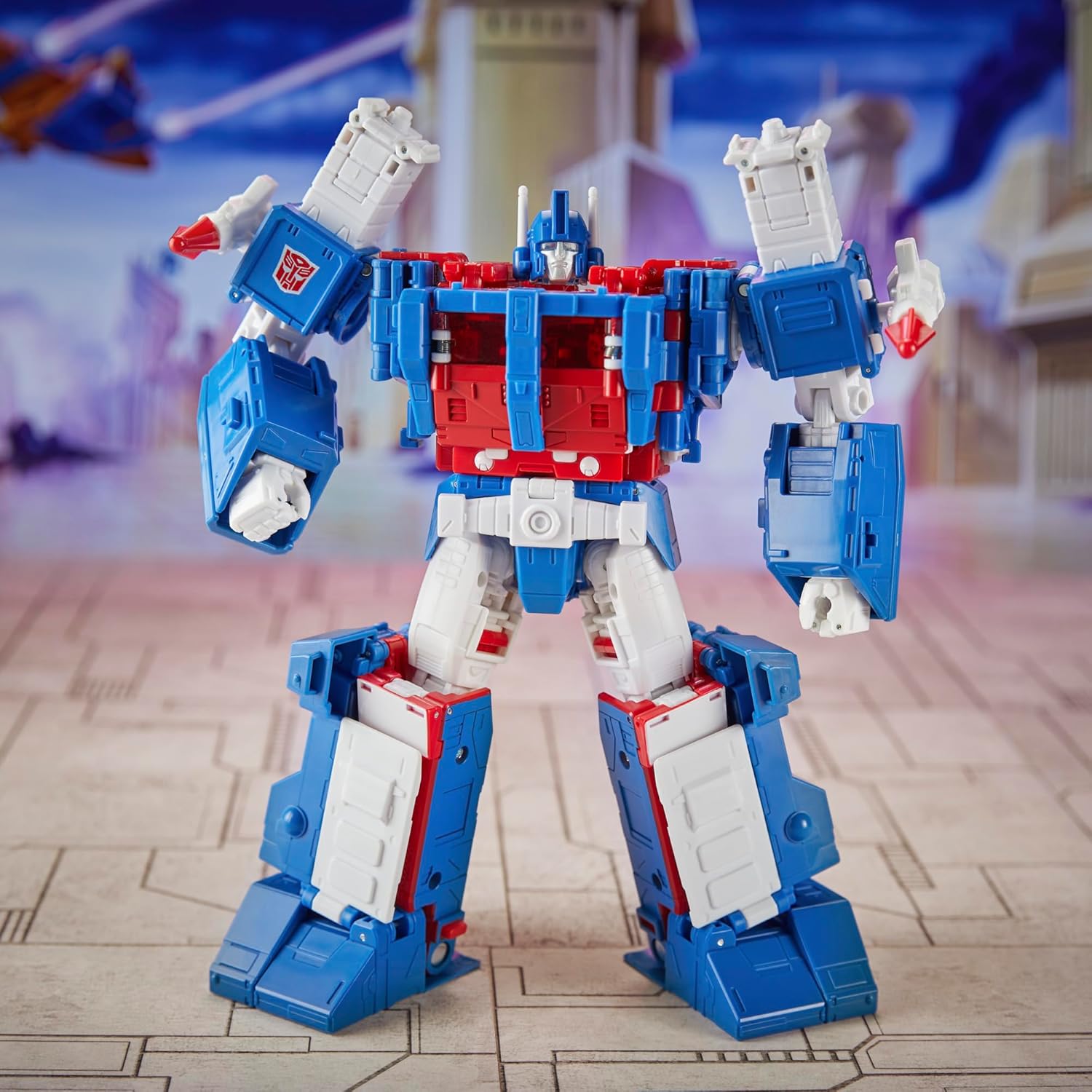 Transformers Ultra Magnus action figure in red white and blue standing on stone floor with futuristic background