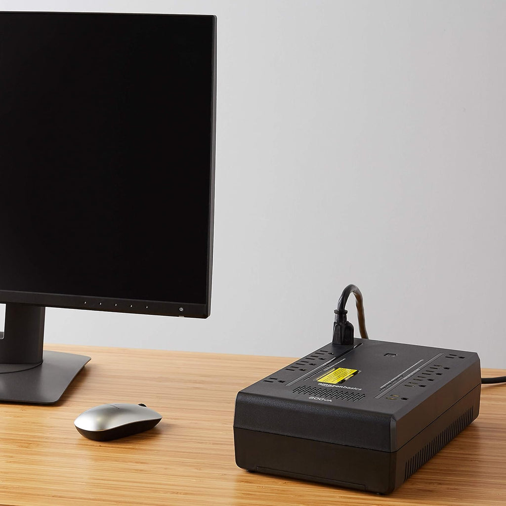 Craques black UPS battery backup for gaming connected on wooden desk near monitor and mouse