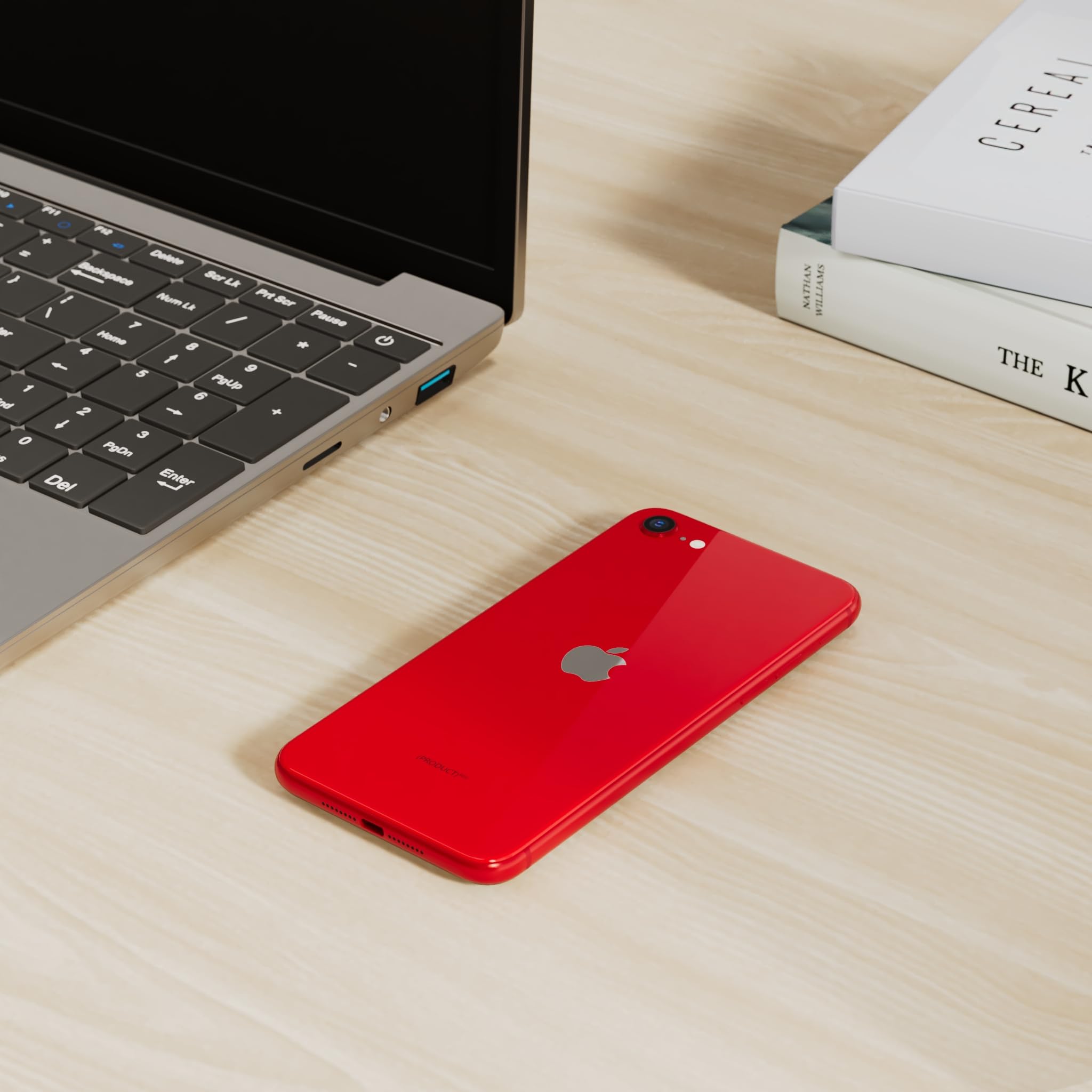 Red unlocked iPhone SE 3rd generation renewed placed on a wooden desk near a laptop and books