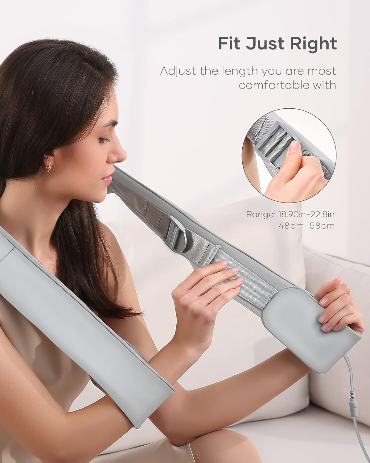 Woman adjusting gray craques back massager with heat strap for a comfortable fit