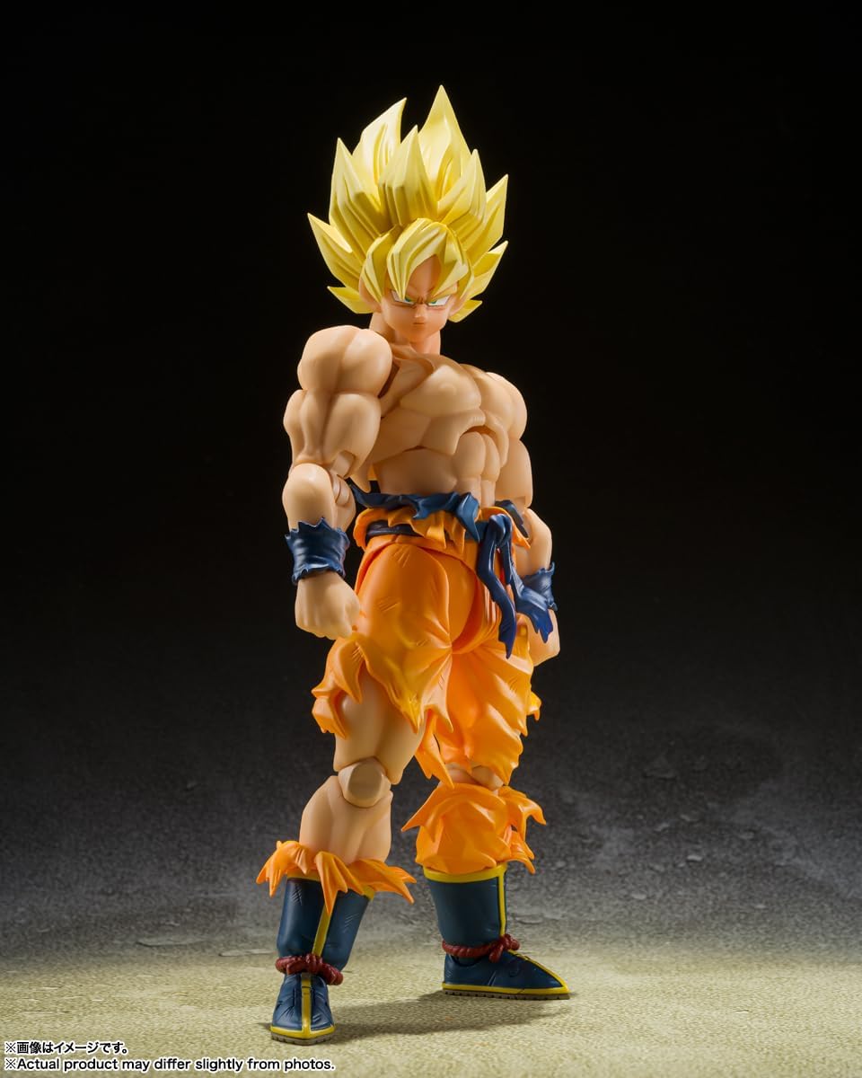 Super Saiyan Son Goku action figure in orange torn pants with yellow spiked hair standing on gray surface