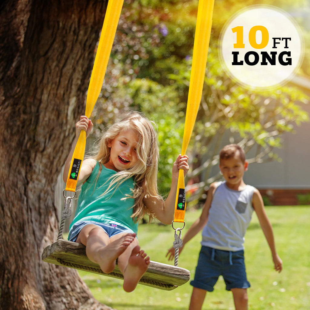 Young girl enjoying outdoor play on a wooden swing with yellow straps from tree swing hanging kit
