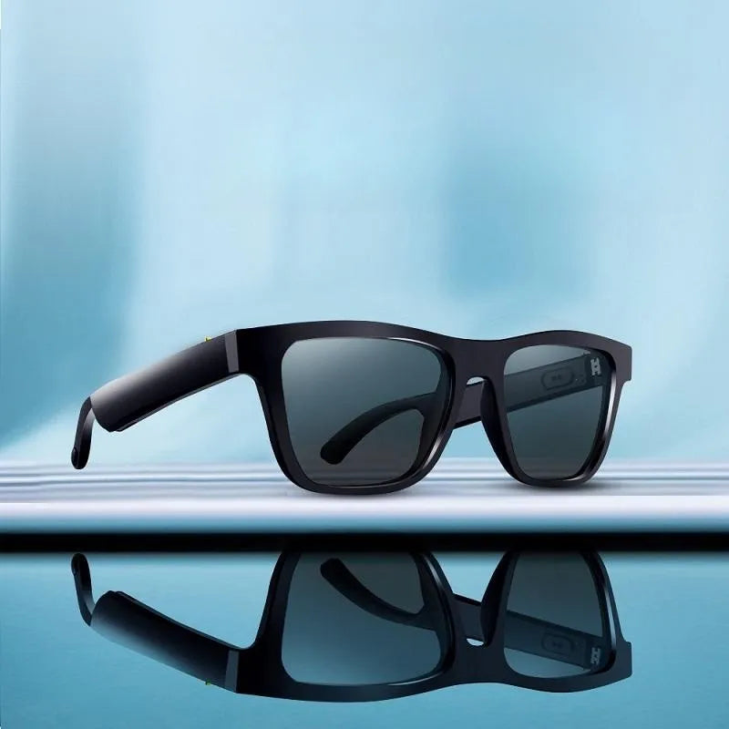 Craques Bluetooth smart glasses with headset in black frame and dark lenses resting on reflective surface