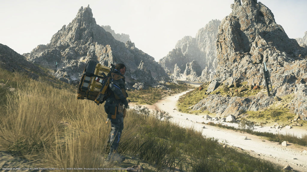Death Stranding 2 Collector's Edition PS5 character carrying cargo walking along mountain path