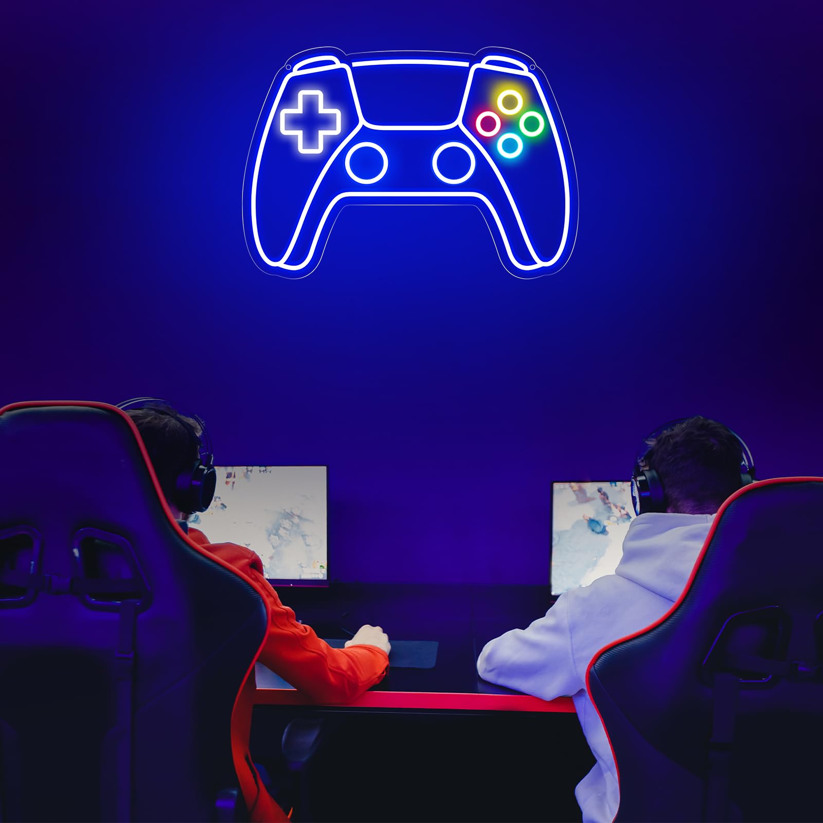 Gamer neon sign shaped like a video game controller glowing above two gamers playing at their computers