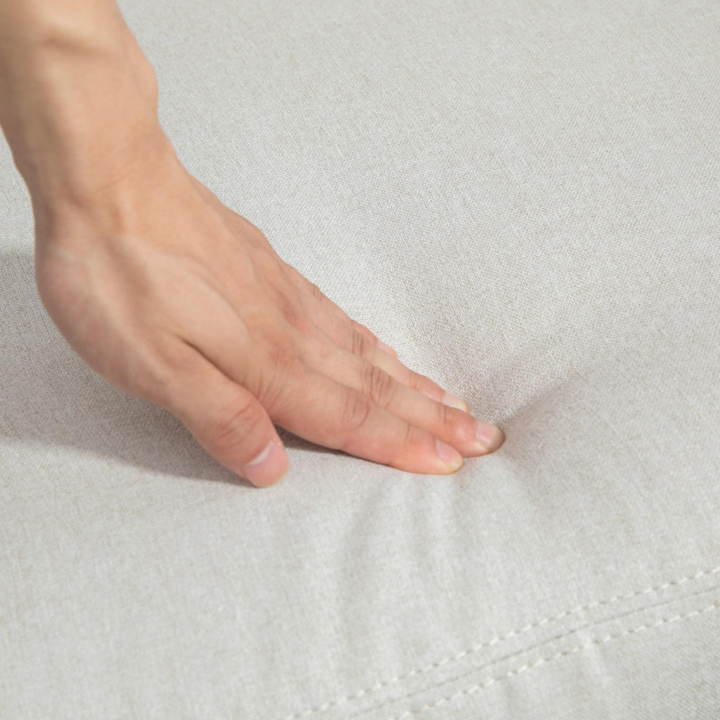 Close-up of hand pressing soft beige fabric cushion of HOMCOM push back recliner chair by craques