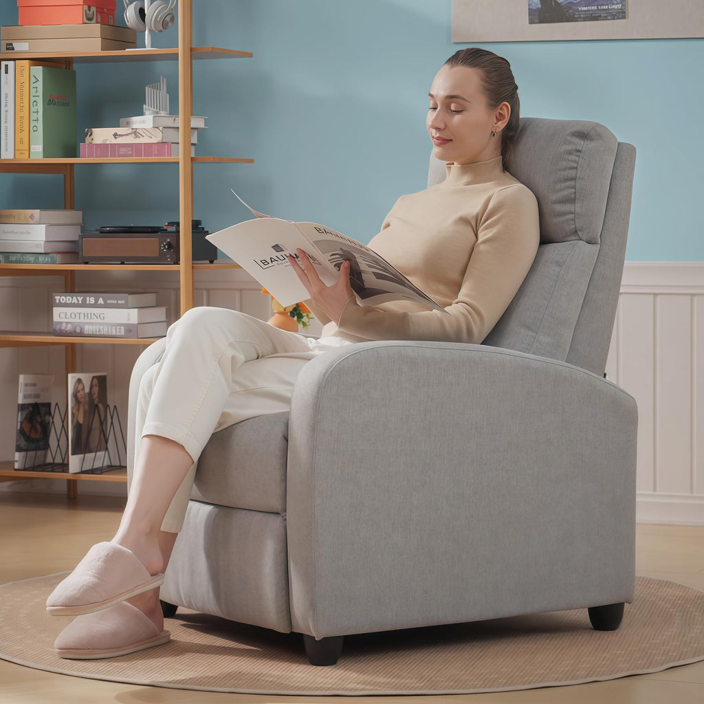 Woman relaxing on a gray HOMCOM push back recliner chair reading a magazine in cozy living room