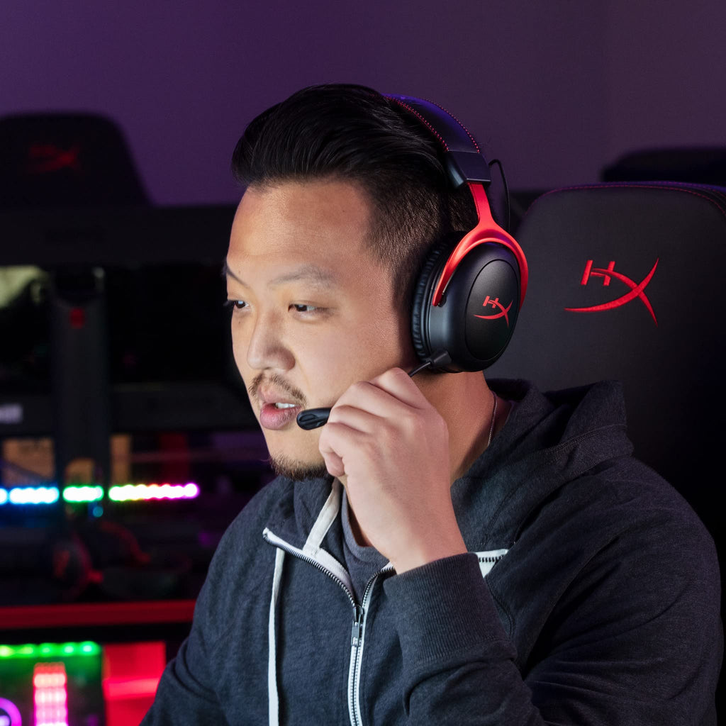 Man wearing HyperX Cloud II gaming headset with microphone sitting in a gaming chair during gameplay