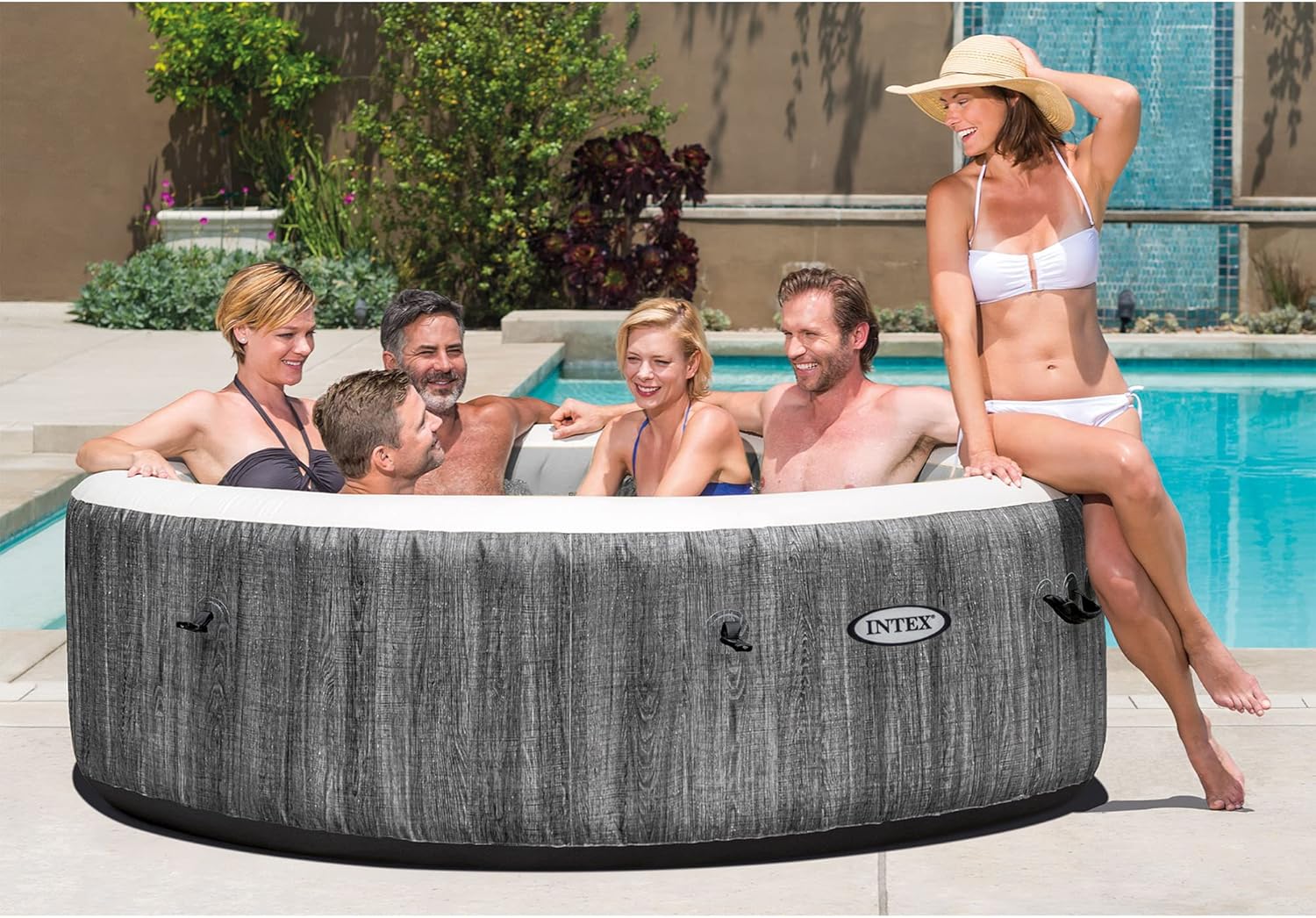 Craques outdoor inflatable hot tub with five adults relaxing by the pool on a sunny day