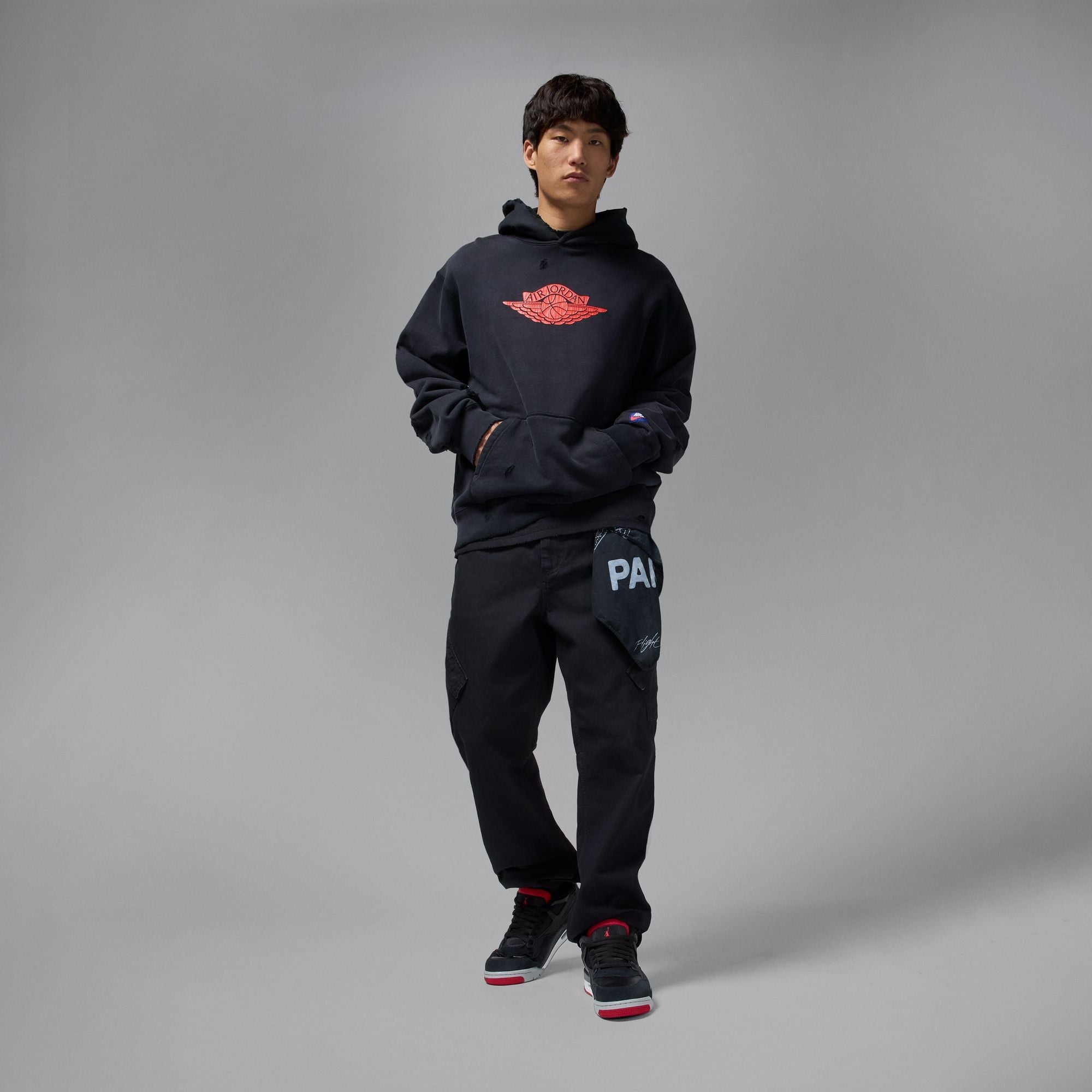 Air Jordan 4 RM men's sneakers styled with black hoodie and pants for a trendy look