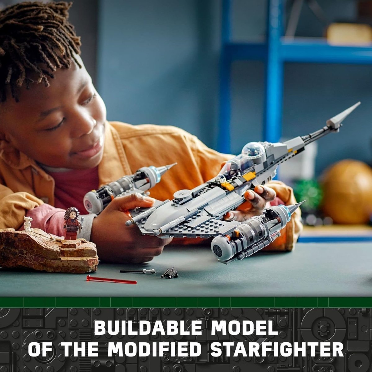 Child holding LEGO Star Wars N-1 Starfighter set buildable model with minifigure on table