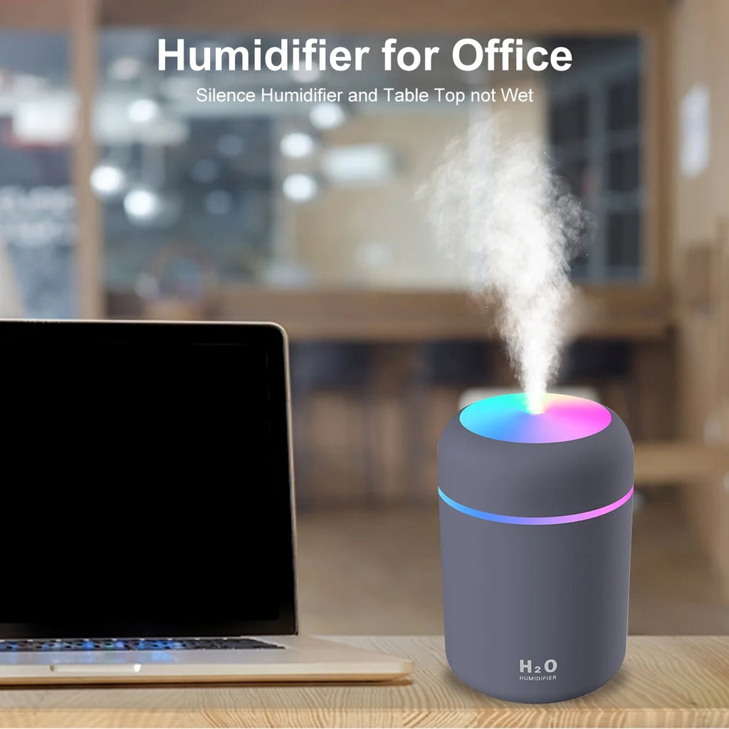 Craques mini USB humidifier for desk with color-changing light and mist beside a laptop
