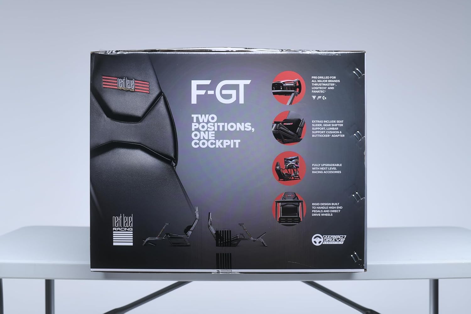 Next Level Racing F-GT simulator cockpit packaging showing product features and two seating positions