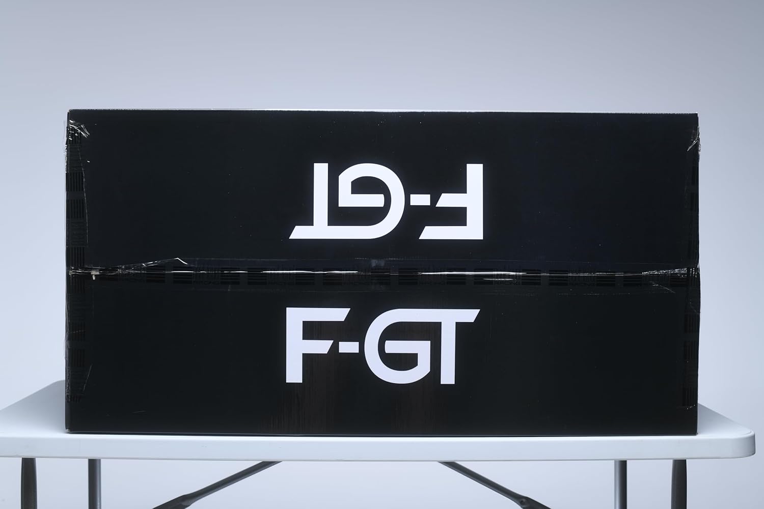 Black shipping box with white F-GT logo containing Next Level Racing F-GT simulator cockpit by craques