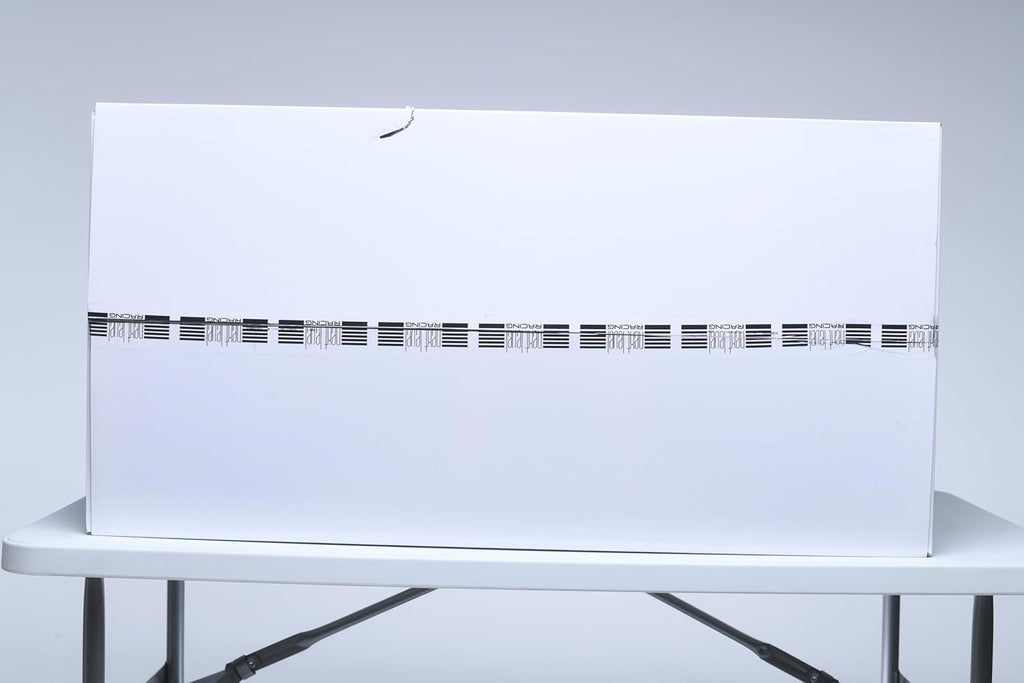 Large white packaging box for Next Level Racing F-GT simulator cockpit on folding table