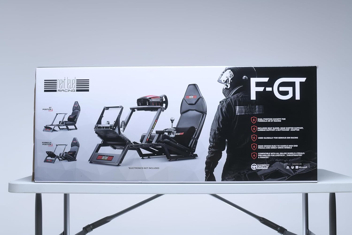 Next Level Racing F-GT simulator cockpit box with image of racing seat and frame on white table