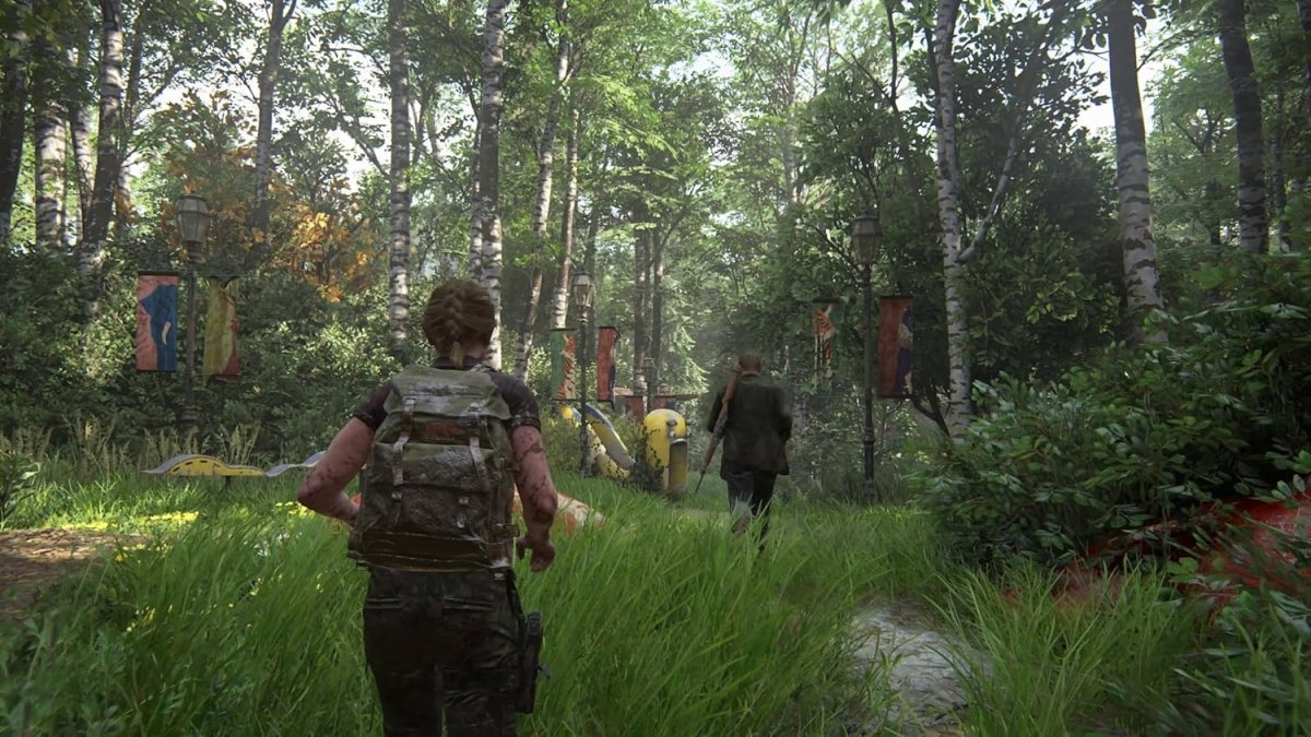 Screenshot from The Last of Us Part II Remastered PS5 showing characters walking through a dense forest with tall grass