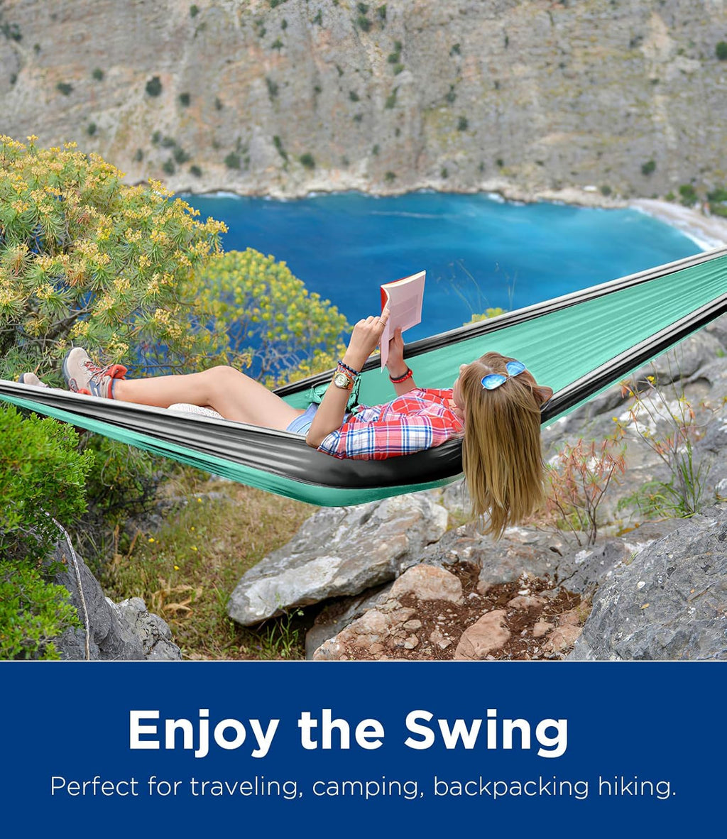 Woman relaxing and reading in a craques ultralight camping hammock with scenic mountain and ocean view