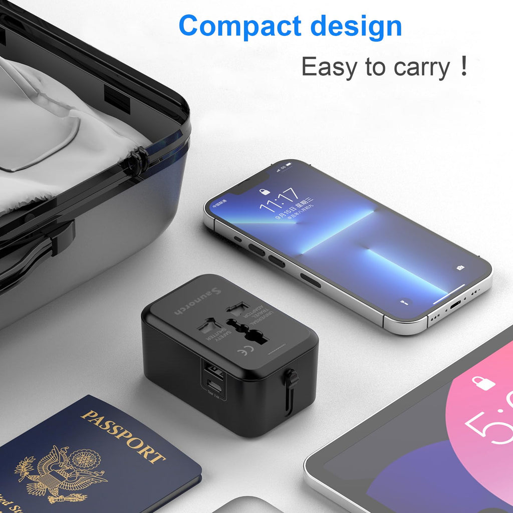Craques universal travel adapter with USB C in compact black design next to smartphone and passport