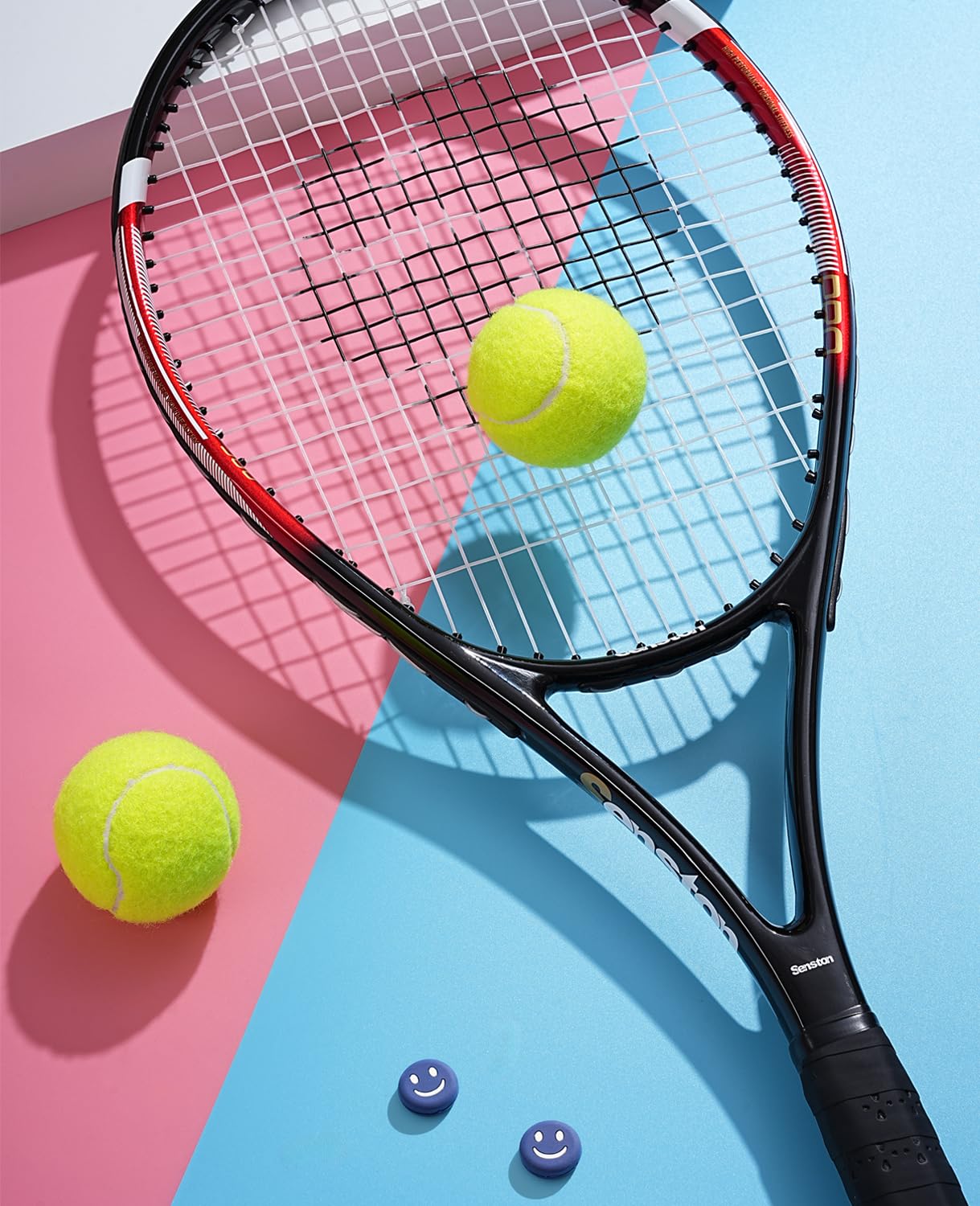 Craques 27 inch tennis racket for adults with black and red frame and two yellow tennis balls on colorful background