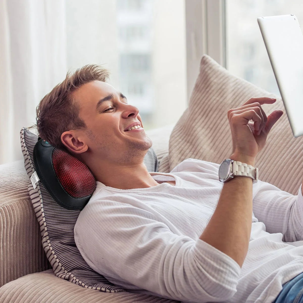 Craques shiatsu back and neck massager in use by a man relaxing on a couch with tablet