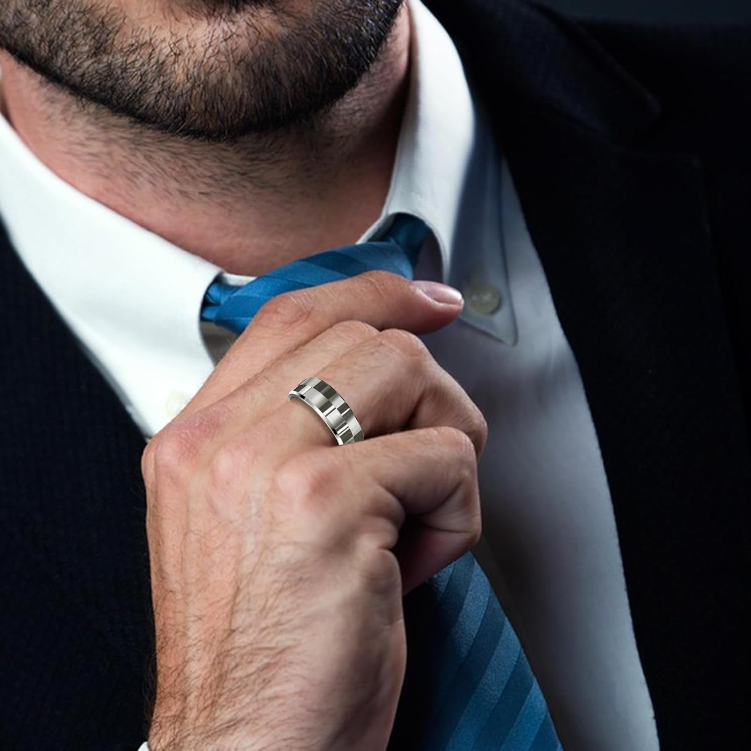 Man wearing a sleek silver smart ring health tracker on finger adjusting blue striped tie