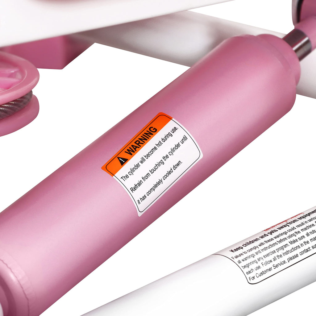 Close-up of pink hydraulic cylinder with warning label on mini stepper for home use by craques