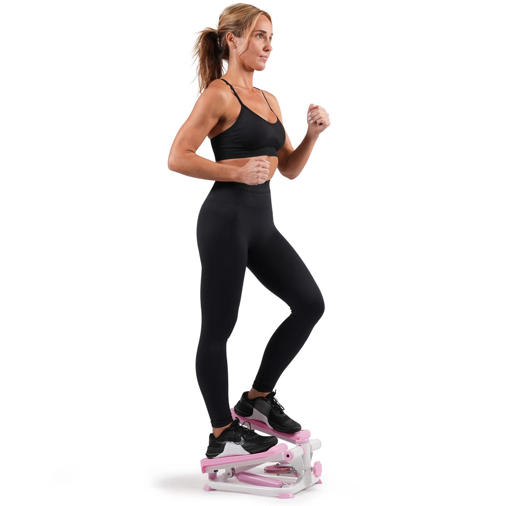 Woman exercising on a pink and white mini stepper for home use wearing black workout clothes
